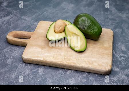Food background with fresh sliced avocado on a wood cutting board Stock Photo