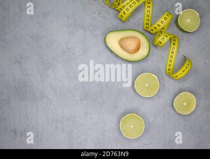 Fresh fit avocado and lime on the grey table. Superfood diet concept Stock Photo