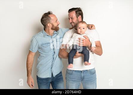 gay or homosexual male couple with their daughter baby over white background Stock Photo