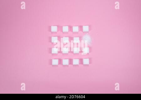 White sugar cubes on pink background composition. Stock Photo
