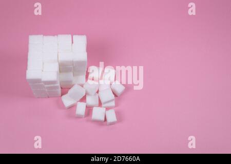 White sugar cubes on pink background composition. Stock Photo