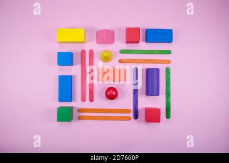 Minimalist composition of geometrical shapes on flat surface. Different shapes with different colors. Kids wooden toys. Stock Photo