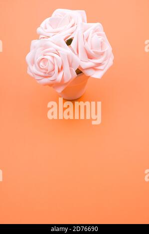 Top view closeup of three artificial light pink roses placed in a pot Stock Photo