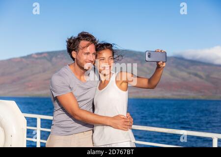 Cruise ship couple taking selfie phone photo Travel in Hawaii holiday. Two tourists lovers on honeymoon travel enjoying summer vacation Stock Photo