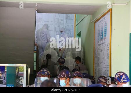 Mandalay, Myanmar. 20th Oct, 2020. U Kyaw Myint being escorted to court by police wearing the personal protective equipment suit PPE.The United Democratic party chairman, U Kyaw Myint who was arrested for absconding, was arraigned for the third time in Chan Aye Thar Zan Township Court. Credit: SOPA Images Limited/Alamy Live News Stock Photo