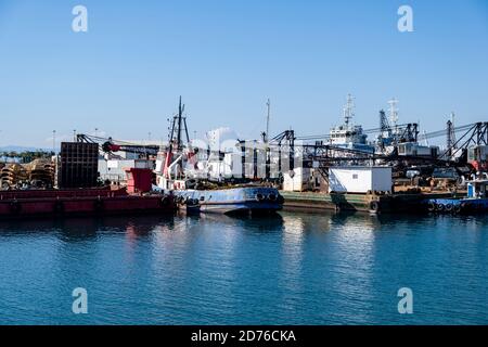Industrial ships and boats moored in old harbor of Drapetsona Piraeus Greece, blue sky and sea, sunny day. Stock Photo