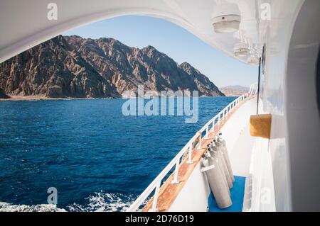 dive boat in the Red sea with dive tanks and mountains on the shoreline Stock Photo