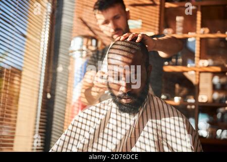 Barber applying talcum powder on client neck Stock Photo