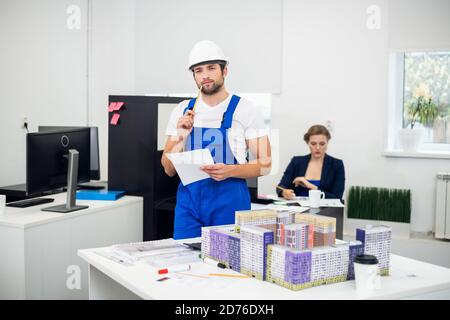 Young construction supervisor taking notes in the office. Stock Photo