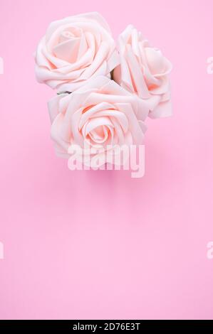 Top view closeup of three artificial light pink roses placed in a pot Stock Photo