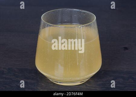 transparent glass on a wooden surface with Vitamin C effervescent tablet, orange flavor Stock Photo