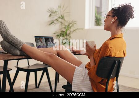 Woman having a video call with family. Family separated by the pandemic staying in connected via video call. Stock Photo
