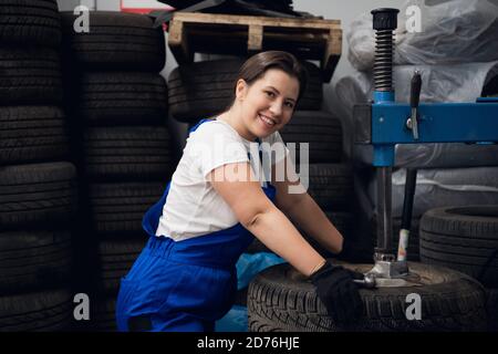 Happy workwoman is using a press and looking at the camera Stock Photo