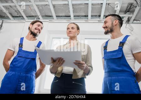 Customer discusses with the builder the details of building a house. They smiling Stock Photo