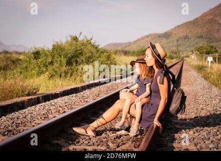 Mother with the daughter go on rails, sit on the rails on nature, in the summer Stock Photo