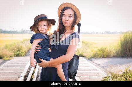 Mother with the daughter go on rails, on nature, in the summer Stock Photo