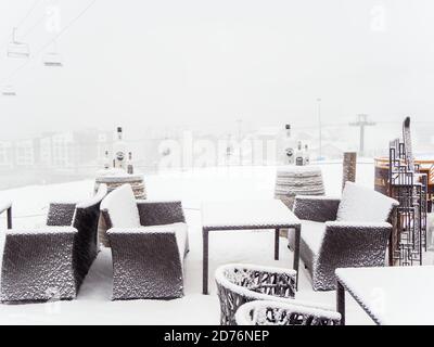 Russia, Sochi 22.01.2020. Wicker tables and chairs of a street cafe on the background of the cable car in the fog Stock Photo
