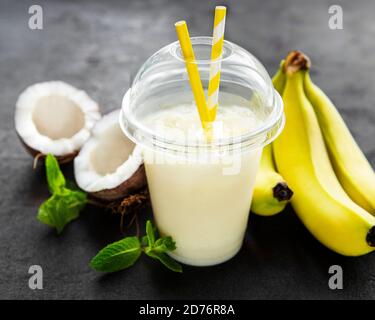 Pina colada alcoholic fresh cocktail served cold with coconut and banana on a black  background Stock Photo