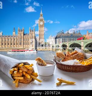 Big Ben against fish and chips served on the table in London, United Kingdom Stock Photo