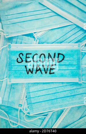 Top view shot of disposable face masks with 'SECOND WAVE' written on the top one