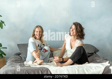 Two friends having fun in the bedroom on the bed. Stock Photo
