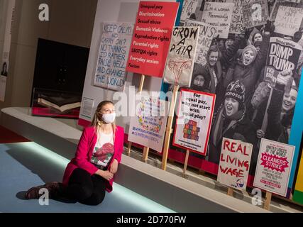 A member of staff views placards from the 2017 Women's March, and demonstrations in 2019 at a preview of 'Unfinished Business: The Fight for Women's Rights', a new exhibition on women's rights at the British Library in London. Stock Photo