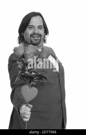 Happy fat Caucasian businessman smiling giving red roses and heart ready for Valentine's day Stock Photo