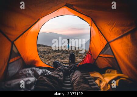 Morning view to the mountain from inside tent. Hiker enjoy view outside, with camp stove, free hike vacation Stock Photo