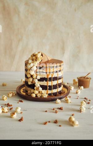 Delicious cake topped with caramel cream and a cone filled with popcorn on it Stock Photo
