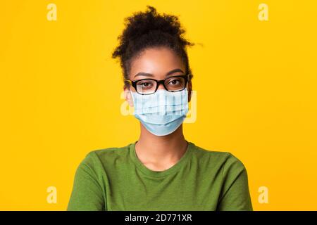 Portrait of black woman wearing medical mask and glasses Stock Photo