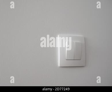 White light switch on a white wall Stock Photo