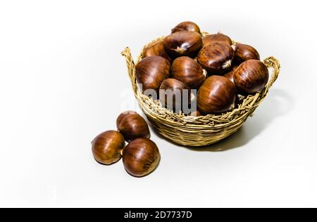 Chestnuts in wicker basket on white background Stock Photo