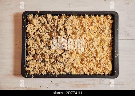 Top view of freshly baked plum and apple cake in a pan on a white table Stock Photo