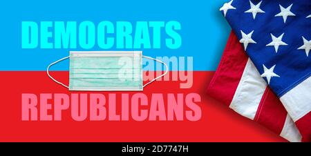 US America elections 2020, COVID 19. Democrats republicans text, USA flag and medical masks on red blue background. Stock Photo