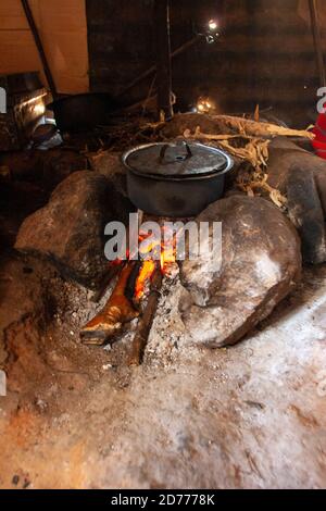 cooking on an open fire in the interior of a hut in a Samburu tribe Village. Samburu are a Nilotic people of north-central Kenya. Samburu are semi-nom Stock Photo