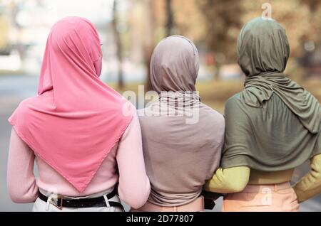 Three Unrecognizable Muslim Ladies In Hijab Walking Outdoor Stock Photo