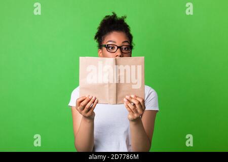 Focused african american woman wearing glasses reading book Stock Photo