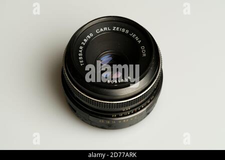 Carl Zeiss Jena DDR 50mm f2.8 Tessar lens laying on white table Stock Photo