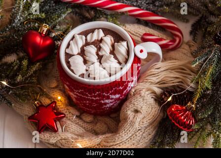 Glass cup of Hot chocolate with marshmallows in knitted cup holder with  cookies, chopping chocolate and mittens over wooden wind Stock Photo - Alamy