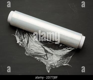 roll of wound white transparent film for wrapping food, black background, close up Stock Photo