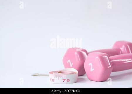 Fitness concept with dumbbell and measurement tape on white background  Stock Photo