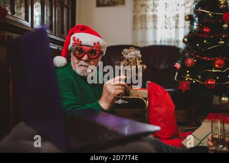 Senior man at home having a Christmas celebration on a video call Stock Photo