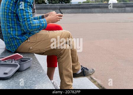 Man in casual clothes sitting anf hanging remote control from drone. Stock Photo