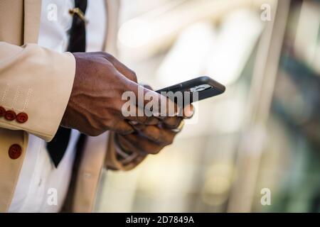 Close up of african-american businessman who is using smartphone. Stock Photo