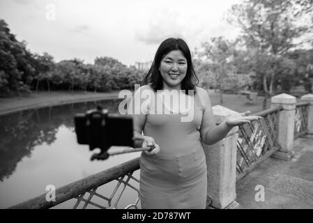 Beautiful overweight Asian woman relaxing at the park in the city Stock Photo