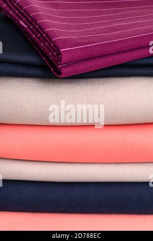 Stack of neatly folded clean colored linens: duvet covers, sheets, pillowcases. The concept of housework and storage. Close-up Stock Photo