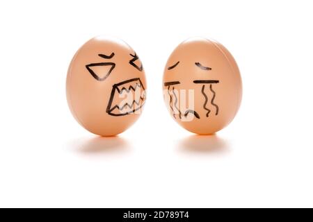 egg faces of an angry one blaming a crying one on white with clipping path Stock Photo