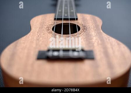 Brown ukulele on black background with shallow depht of field Stock Photo