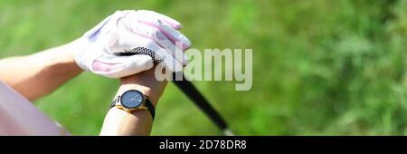 Female hands in gloves holding golf club close-up Stock Photo