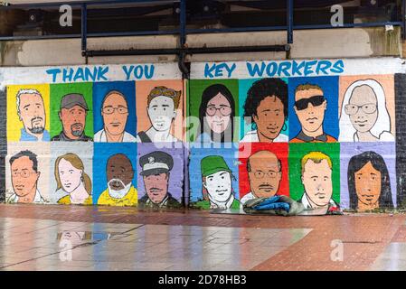 COVID 19 Key workers thank you street art with bedding of a homeless person on a wet, grim day. High Street, Southend. Raining. Deprived area Stock Photo